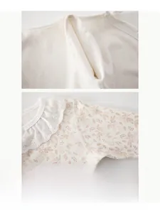 Détail de la barboteuse en coton pour bébé avec col en dentelle et coutures plates douces