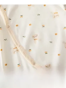 Close-up of baby romper with floral bunny print and snap buttons on soft cotton fabric