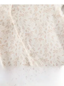 Détail de la grenouillère bébé en coton doux avec motif lapin et boutons-pression blancs