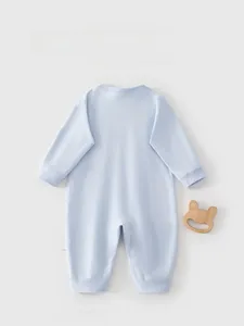 Detail view of the back of a light blue long-sleeve cotton baby romper with care label