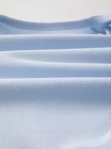 Macro close-up of light blue soft cotton fabric with breathable knit texture for infants