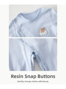 Detail of baby romper with resin snap buttons and cute bear embroidery on cotton fabric