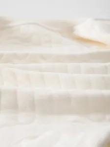 Vue détaillée de la texture du coton matelassé respirant pour combinaison bébé
