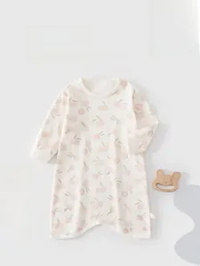 Detail of soft cotton baby sleepsuit featuring pink peach floral pattern and long sleeves