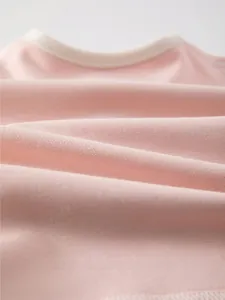 Close-up of soft pink fine-spun cotton fabric with breathable knitting texture for baby wear