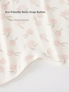 Close-up of baby romper with pink cherry print and eco-friendly resin snap buttons