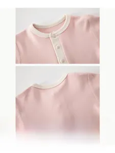 Detail of pink waffle knit baby top showing soft neckline trim and delicate front buttons