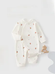Detail of baby cotton romper with orange cherry print and soft ribbed cuffs