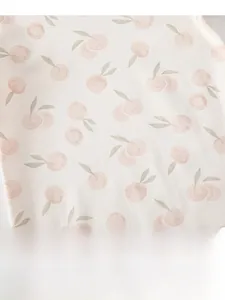 Close-up of soft cotton knit fabric with cute pink apple pattern for baby sleepwear