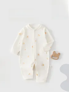 Détail d'une grenouillère bébé en coton doux avec motifs lapins orange et pressions