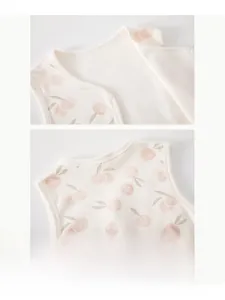 Détail de l'encolure du gilet en coton pour bébé avec imprimé cerise et pressions