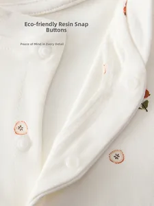 Detail of eco-friendly resin snap buttons on cotton baby romper with pear print