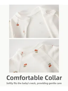 Close-up of baby cotton romper with red berry pattern and comfortable round neckline