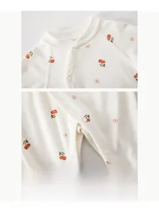 Close-up of resin snap buttons on cotton baby bodysuit with orange fruit print