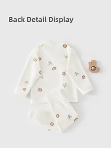 Détail de l'ensemble pyjama pour bébé en coton avec motifs de lions et décorations