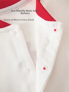 Detail of red and white cotton baby romper featuring eco-friendly resin snap buttons