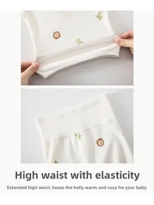 Détail du pantalon bébé taille haute avec imprimé lion montrant l'élasticité et le coton doux