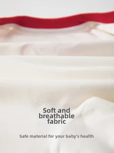 Close-up of fine-spun soft cotton baby bodysuit with red trim and breathable texture
