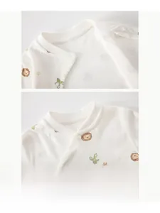 Détail de l'encolure en coton pour bébé avec imprimés de lion et boutons-pression