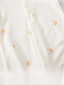 Vue détaillée du tissu en coton doux avec imprimé carottes et lapins sur le body bébé
