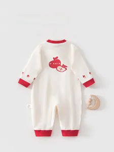 Detailansicht eines Baby-Bodys aus Baumwolle mit Apfelprint und roten Bündchen