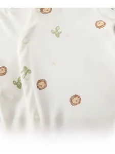 Gros plan d'un body bébé en coton avec motifs lion et boutons-pression pratiques