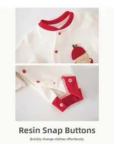 Detail eines Baby-Stramplers aus Baumwolle mit Harzdruckknöpfen und Bestickung