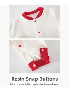 Detail view of smooth resin snap buttons on the collar and crotch of a baby cotton romper