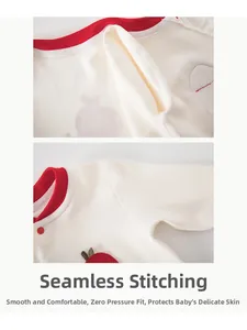 Detail eines Baby-Baumwoll-Bodys mit Flachnähten und roter Apfelstickerei