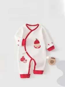 Detail of newborn long sleeve cotton romper with red trim and embroidered bear pattern
