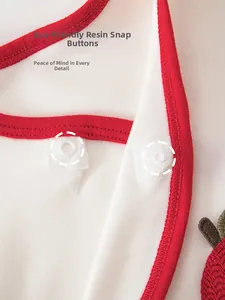 Detailed macro view of eco-friendly resin snaps on red-trimmed cotton baby bodysuit