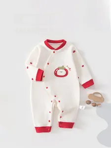 Close-up of red apple embroidery and snap button closure on a warm baby romper