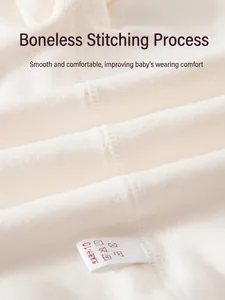 Detailed view of seamless stitching on a cream-colored soft cotton baby jumpsuit