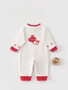 Detail of baby cotton romper back with apple print, ribbed cuffs and laundry label