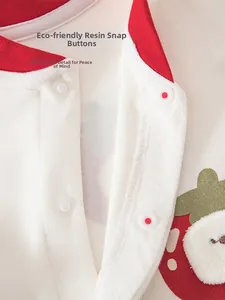 Detail of eco-friendly resin snaps and strawberry embroidery on cotton baby bodysuit