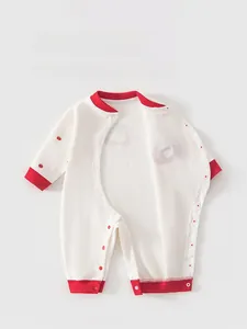 Detail of baby cotton romper featuring red trim edging and easy-to-use snap button closure