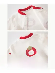 Detail of baby cotton romper neck with red ribbed trim and strawberry print