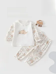 Detail of baby cotton pajama set with floral butterfly patterns and cute sleeping bunny print