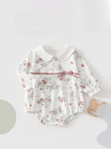 Close-up of cotton baby bodysuit with rose and unicorn prints and Peter Pan collar
