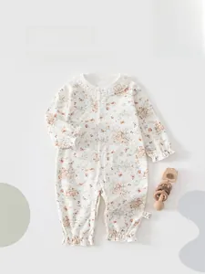 Detail of floral baby romper with delicate lace collar and soft cotton fabric texture