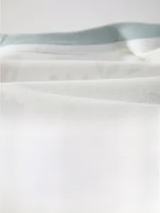Gros plan sur un tissu en coton blanc doux montrant une texture respirante pour bébé