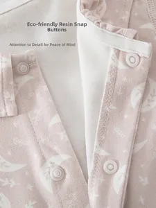 Detail of pink baby romper showing eco-friendly resin snaps and soft printed fabric