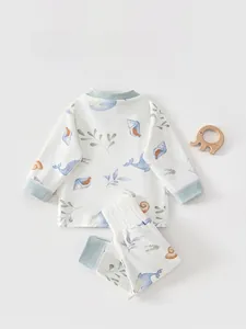 Détail du pyjama en coton pour bébé avec imprimé baleine bleue et protège-ventre haut