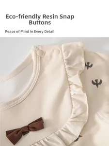 Détail de haut en coton pour bébé avec boutons-pression en résine et col à volants doux