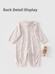 Detailed back view of baby pink long-sleeved romper with ruffles and moon patterns