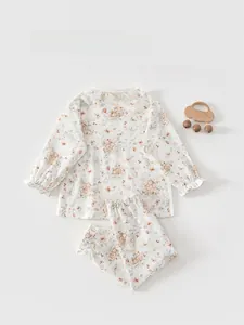 Close-up of cotton baby pajama set featuring delicate floral prints and lace collar details