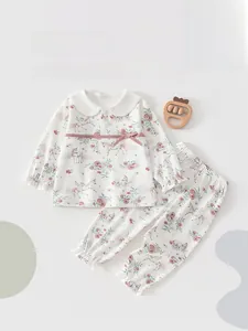 Detail of baby cotton pajama set featuring Peter Pan collar and unicorn floral print