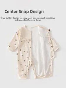 Detail of baby cotton onesie featuring snap buttons and a delicate bird print pattern