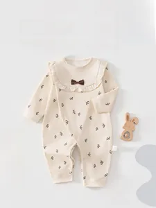 Detail of baby romper with bird print, ruffle collar, and brown bow decoration
