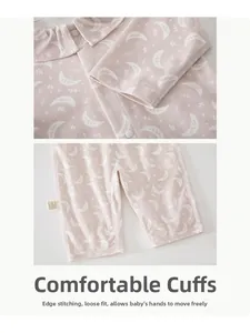 Detail of baby romper featuring soft pink fabric with moon stars print and snap buttons